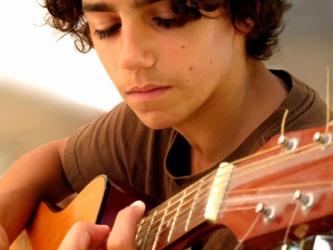 young man taking guitar lessons